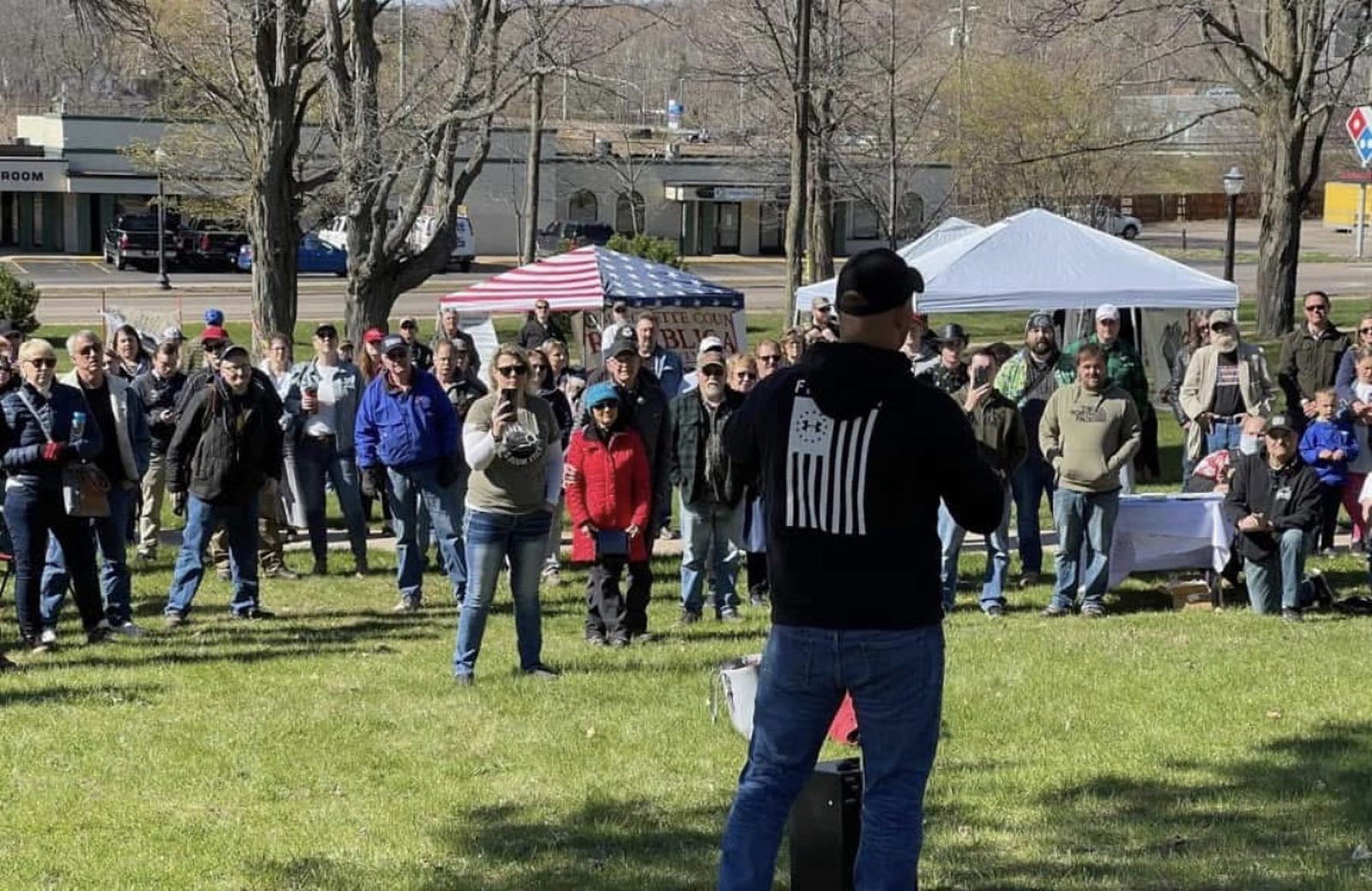 Garrett Soldano speaking to a crowd gathered in a park