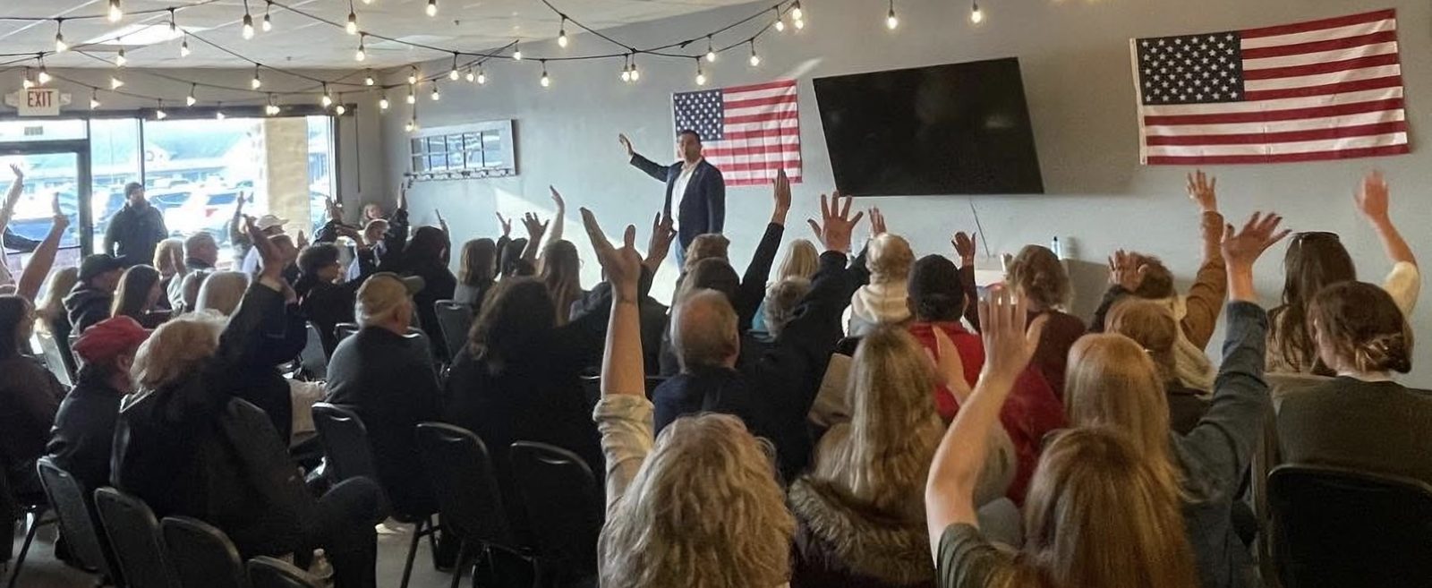 Town hall audience raising their hands as Garrett Soldano speaks