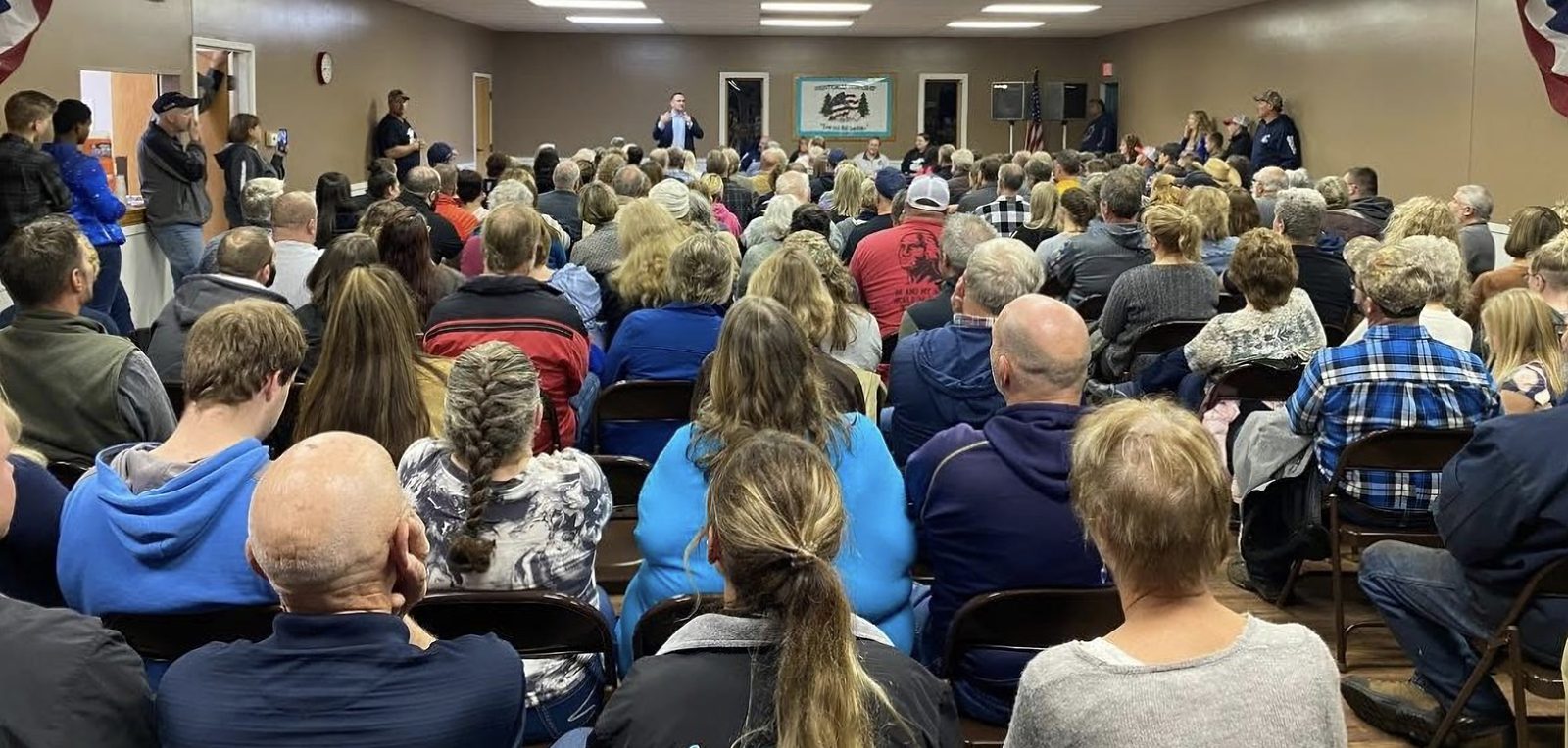 Full community hall with Garrett Soldano speaking at the front